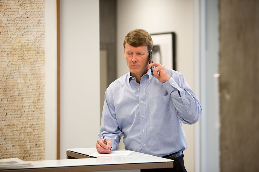 man writing and on phone professional business man blue shirt